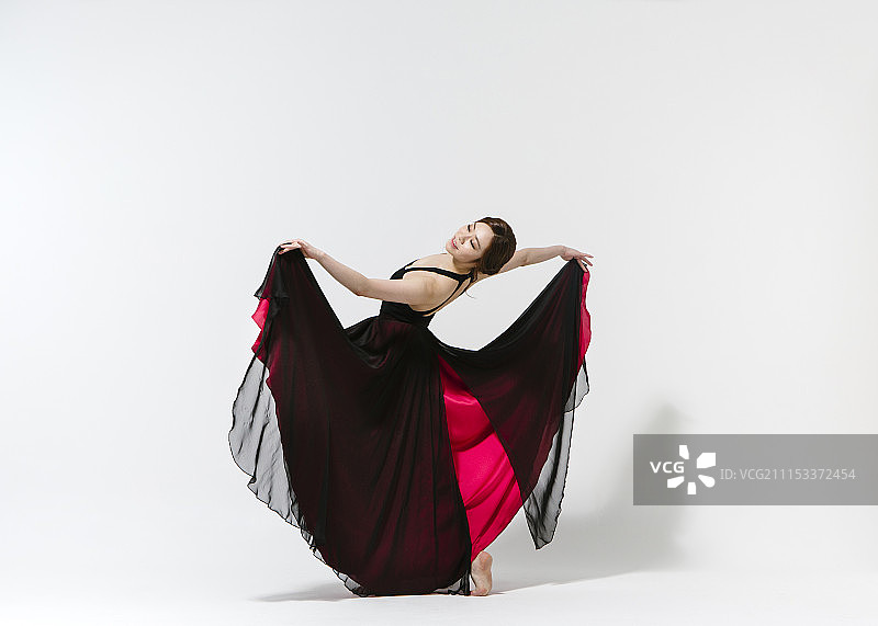 穿着连衣裙在白色背景上跳舞的女人照片图片素材
