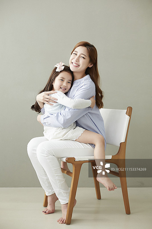 女儿和母亲幸福地坐在椅子上摄影图片素材