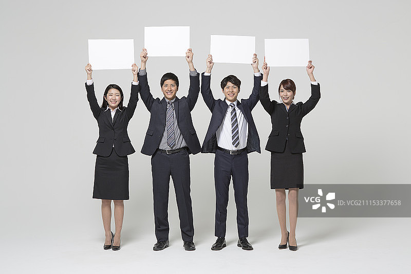 拿着白色banner的微笑的商人们图片素材
