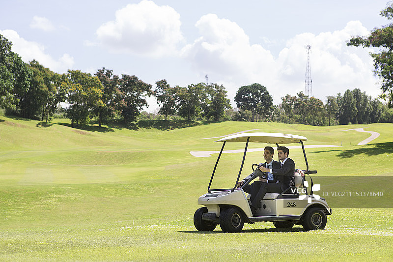 在高尔夫球场上驾车的两位商人图片素材