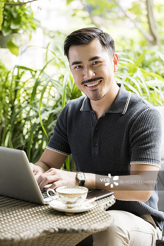 商务男士在庭院使用电脑图片素材