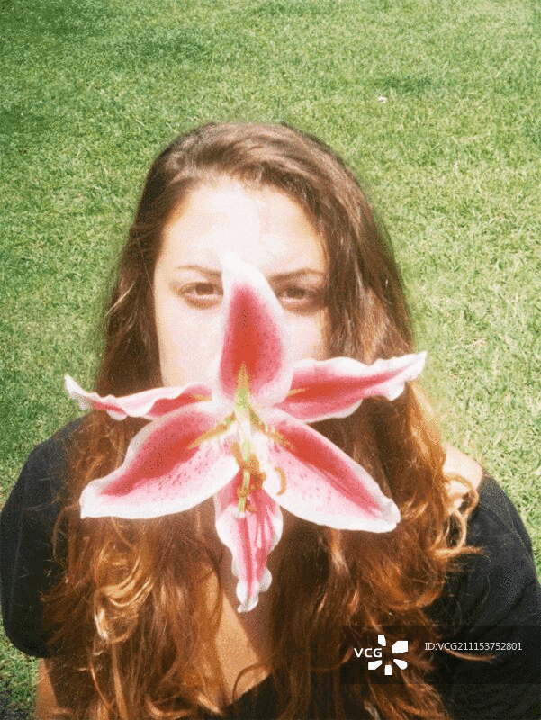 年轻女子嘴里含着兰花图片素材