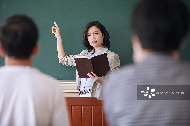 正在给学生上课的年轻女教师图片素材