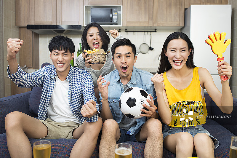 年轻人在客厅看体育比赛图片素材