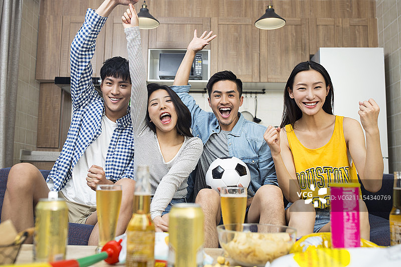 年轻人在客厅看体育比赛图片素材