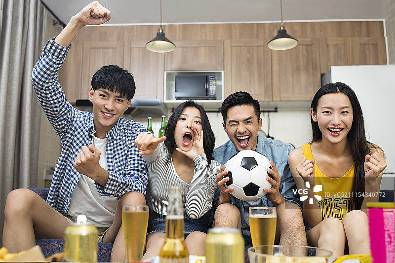 年轻人在客厅看体育比赛图片素材