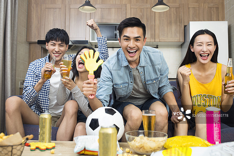 年轻人在客厅看体育比赛图片素材