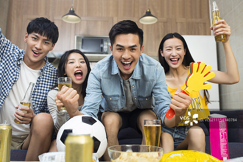 年轻人在客厅看体育比赛图片素材