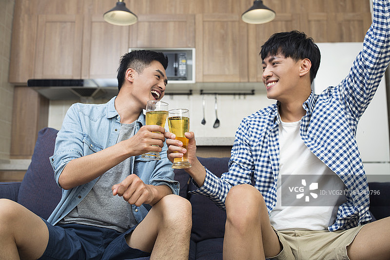 年轻人在客厅看体育比赛图片素材