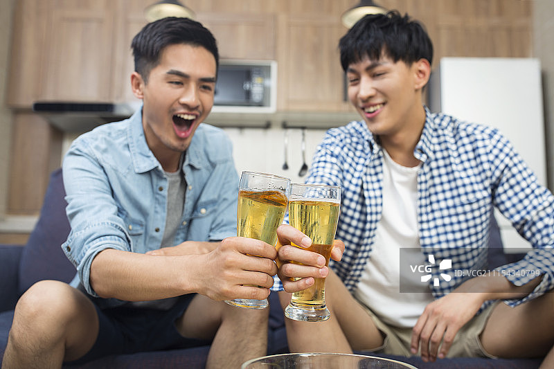 年轻人在客厅看体育比赛图片素材