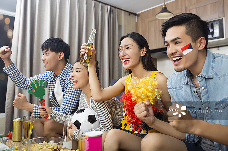 年轻人在客厅看体育比赛图片素材