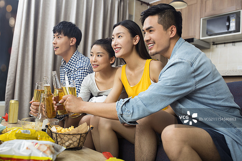 年轻人在客厅看体育比赛图片素材