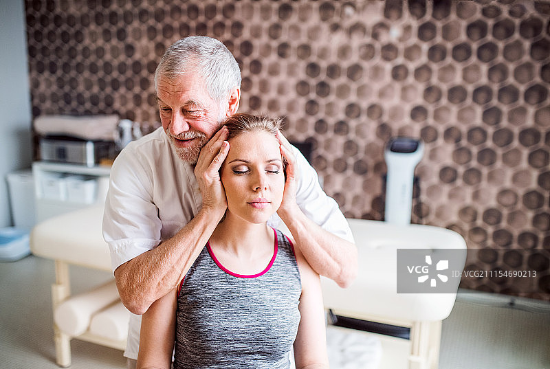 年长的男理疗师与女病人一起工作图片素材