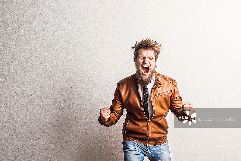 工作室里一位尖叫的年轻潮男肖像，留白图片素材