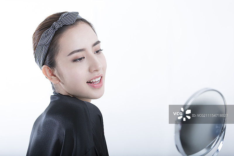 年轻女子照镜子肖像图片素材