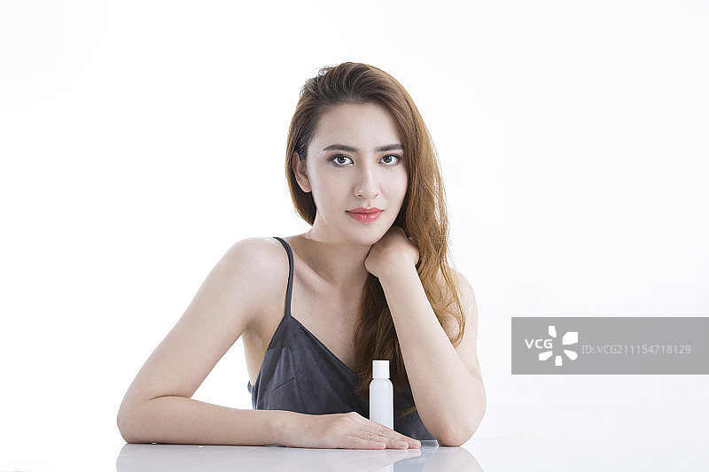 年轻女子展示美容护肤产品图片素材