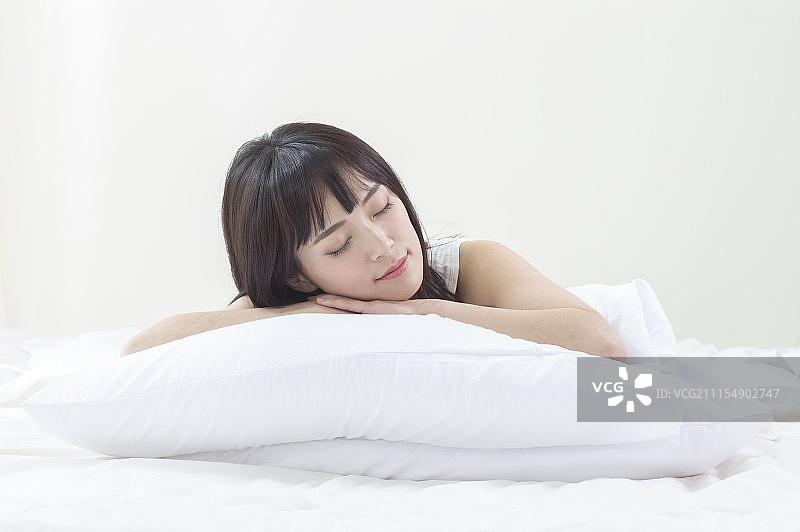 年轻女人趴在枕头上睡觉图片素材