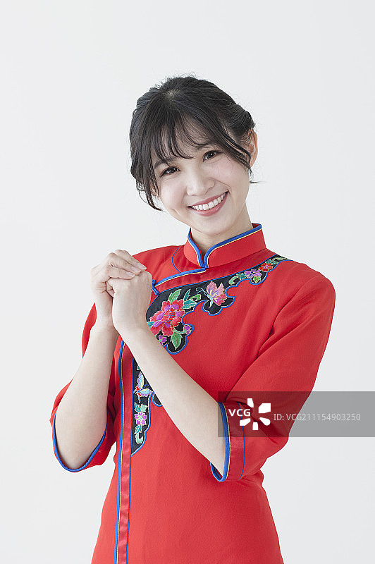 年轻女人穿着旗袍作问候手势图片素材