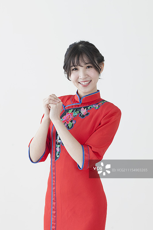 年轻女人穿着旗袍作问候手势图片素材