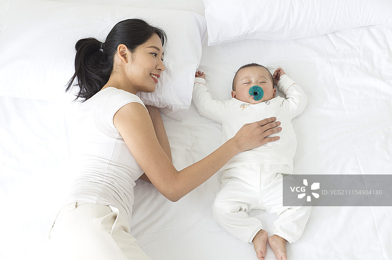 年轻妈妈看着熟睡的宝宝图片素材