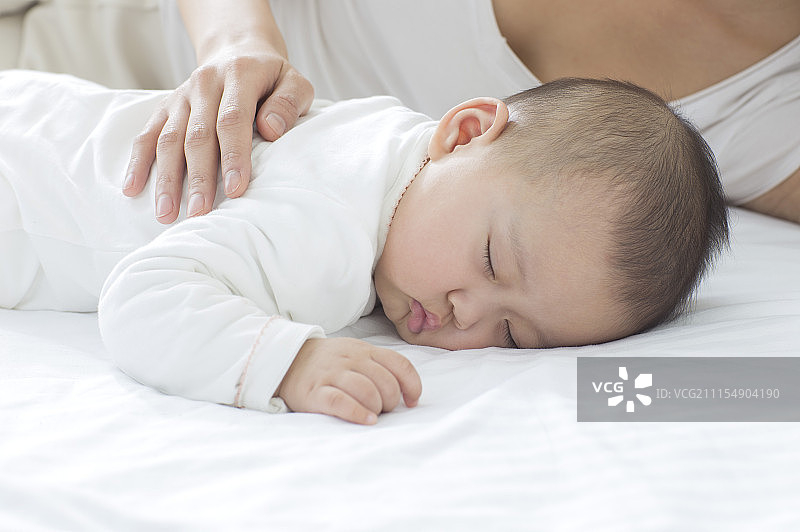 年轻妈妈在哄宝宝睡觉图片素材