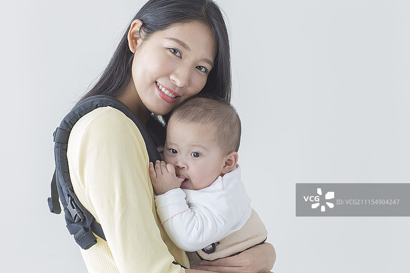 年轻妈妈背着宝宝图片素材