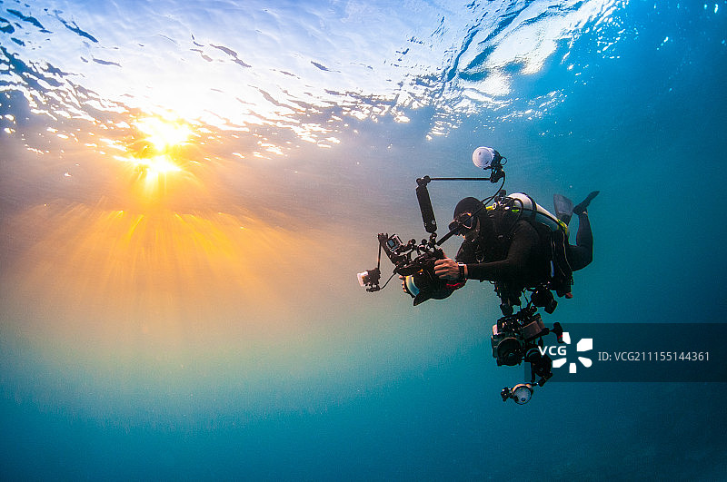 夕阳下海里的摄影师图片素材