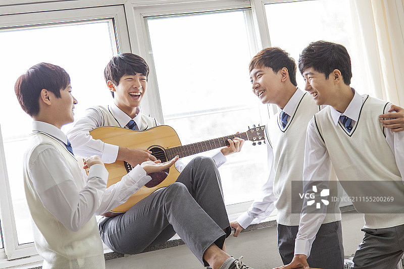 学生在窗边教室弹吉他摄影图片素材