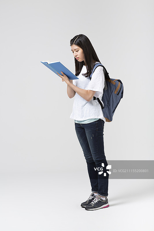 背着书包读书的少女摄影图片素材