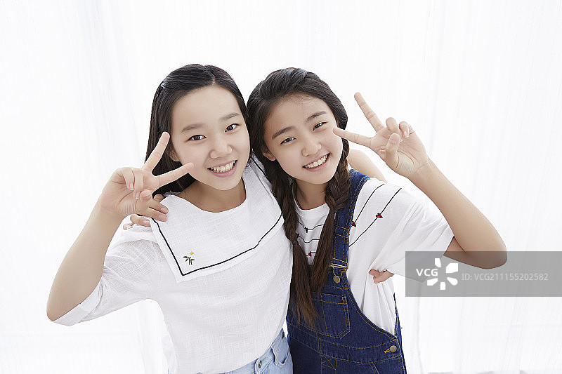两个少女拥抱并做出V手势摄影图片素材