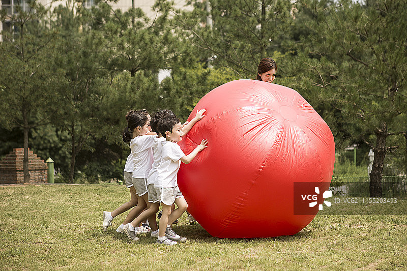 享受运动日滚红球的学龄前儿童摄影图片素材