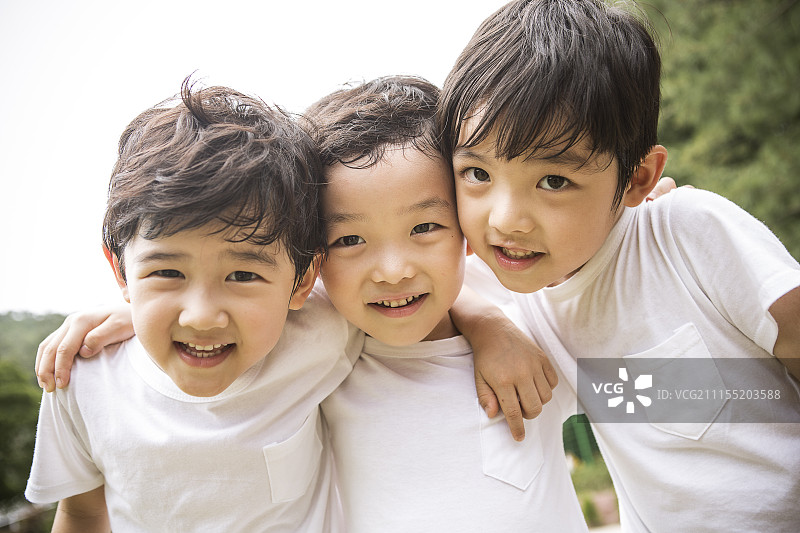 学龄前儿童享受运动会，手臂搭在一起做面部表情的摄影图片素材