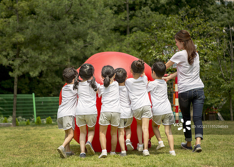 享受运动日滚红球的学龄前儿童摄影图片素材