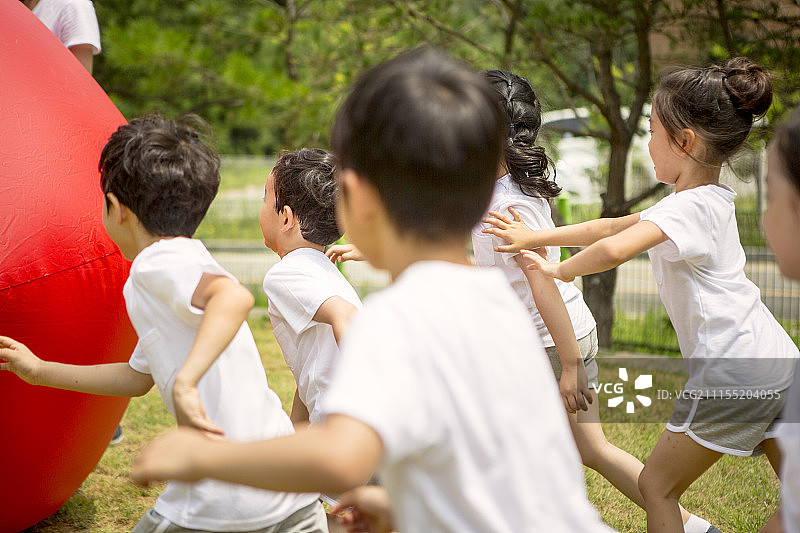 享受运动日滚红球的学龄前儿童摄影图片素材