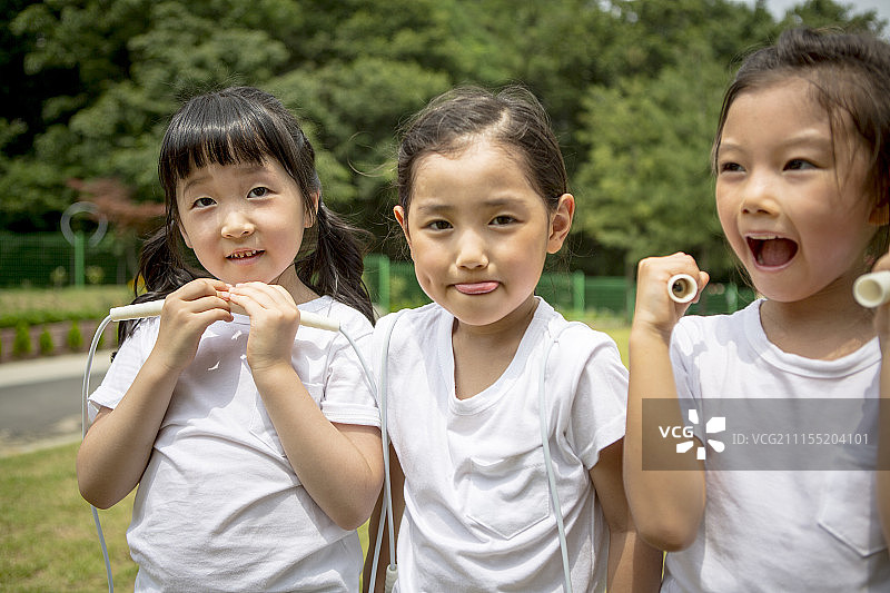 手持绳子享受运动会的学龄前儿童摄影图片素材