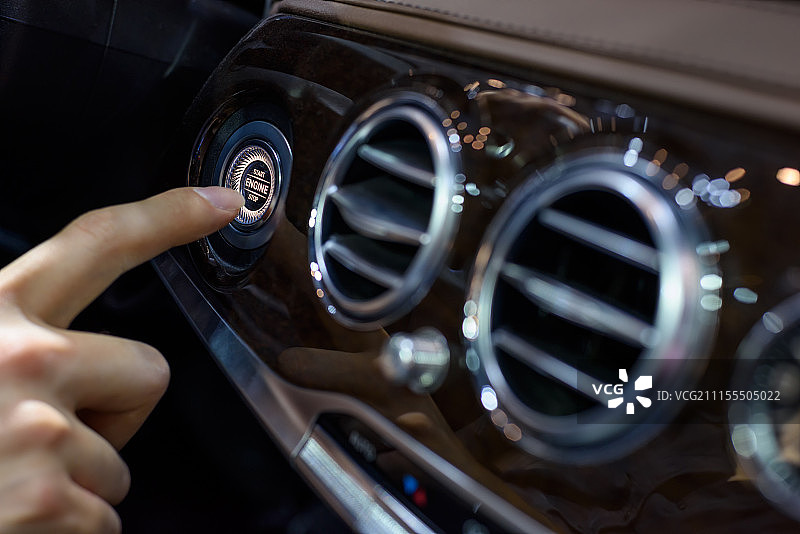 一个男人按动汽车仪表板一键启动按键图片素材