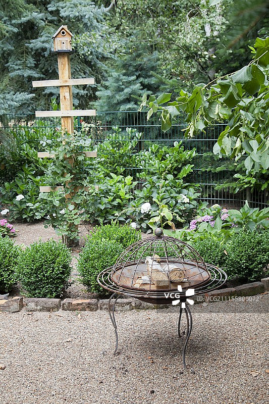 砾石路上的复古火盆与花坛及鸟窝图片素材