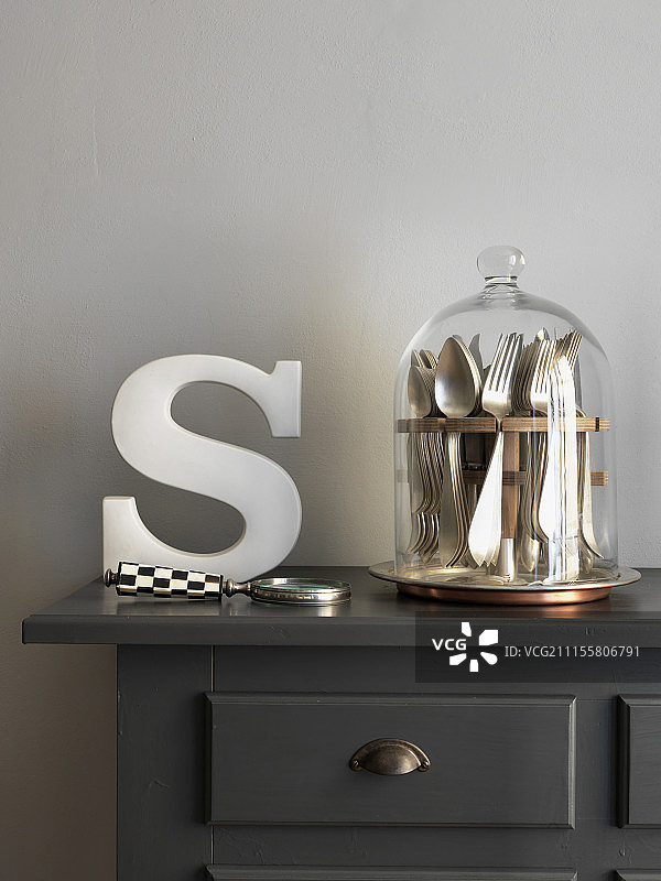 玻璃罩下的银色餐具和装饰字母图片素材