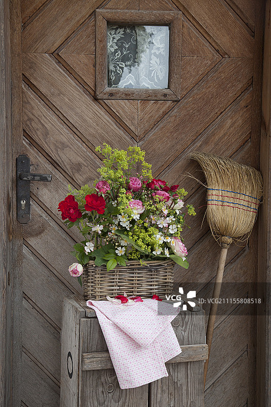 前门前的篮子里的玫瑰花束和斗篷草图片素材
