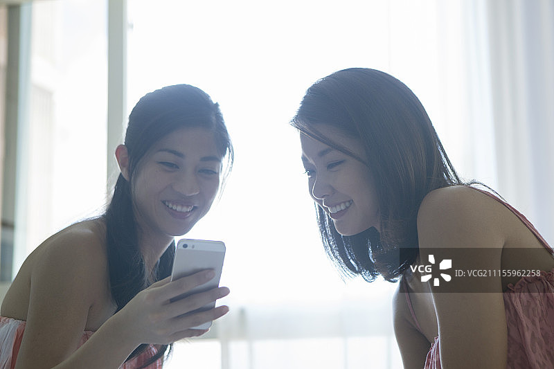 使用智能手机的两个年轻女人图片素材