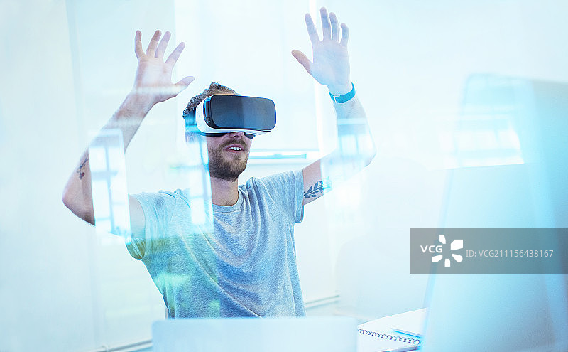 在办公室测试VR模拟器眼镜的男程序员图片素材
