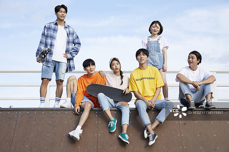 年轻男子和朋友玩滑板图片素材