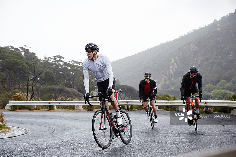 男人在湿滑路面上骑自行车上坡图片素材