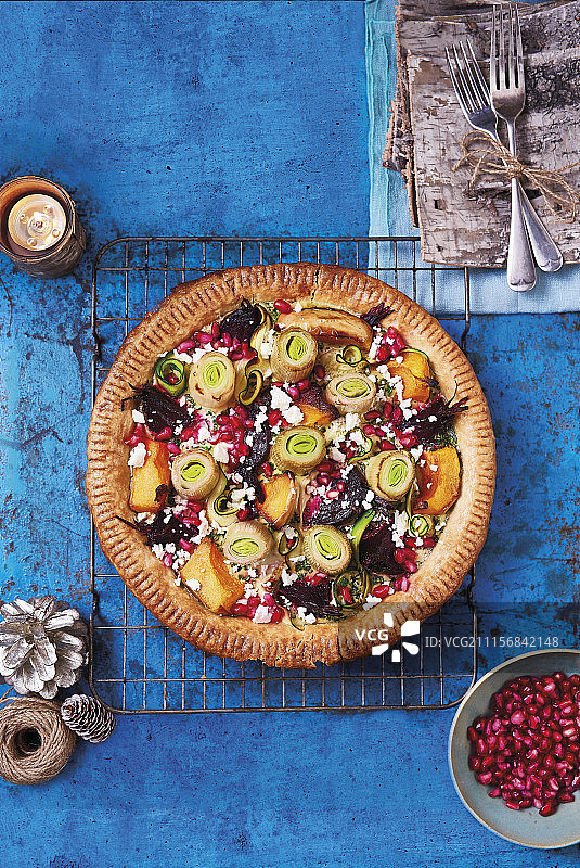 素食圣诞馅饼：西葫芦、冬南瓜、甜菜根和韭葱，搭配菲达奶酪和石榴籽图片素材