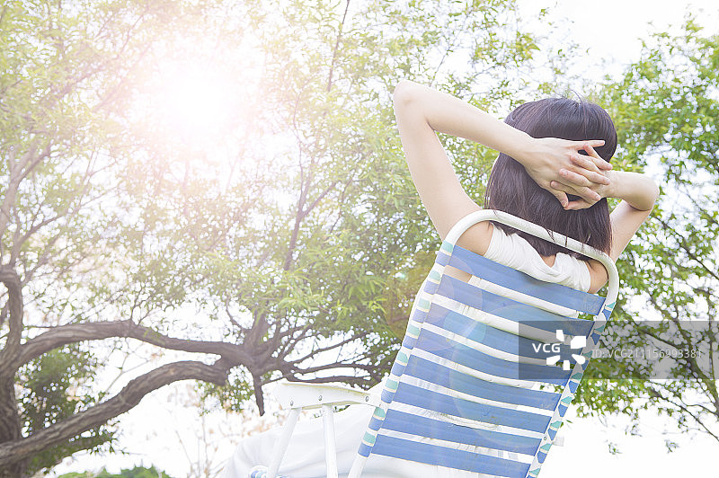 年轻女人坐在躺椅上做日光浴图片素材