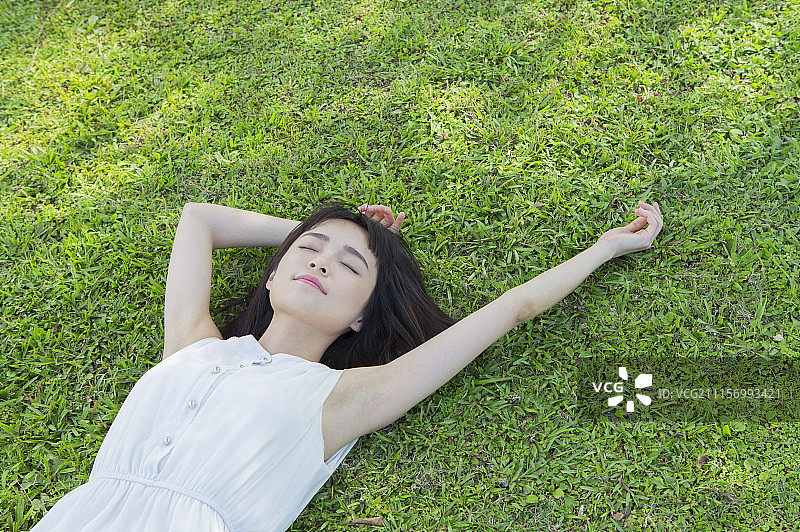 年轻女人躺在草地上睡觉图片素材