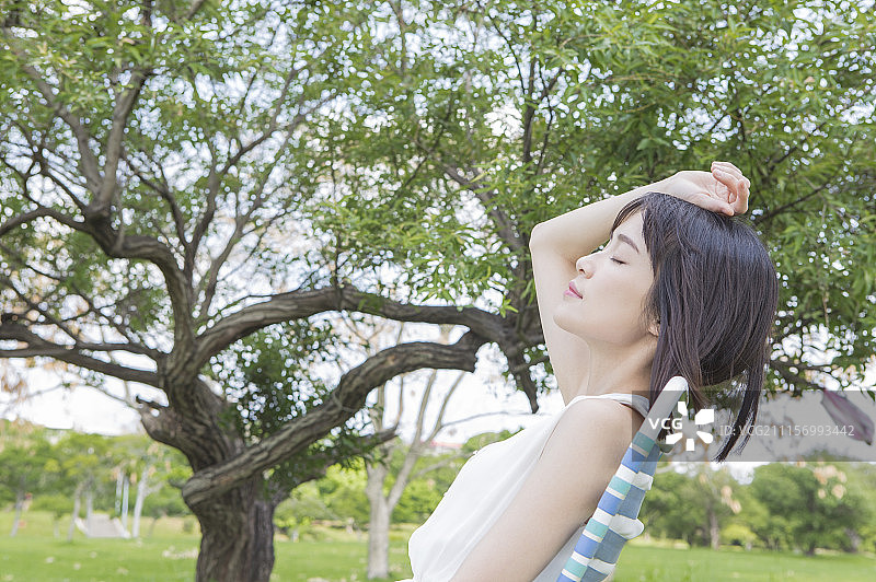 年轻女人坐在躺椅上做日光浴图片素材