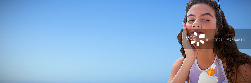 年轻女子在脸上涂抹防晒霜的合成图像图片素材