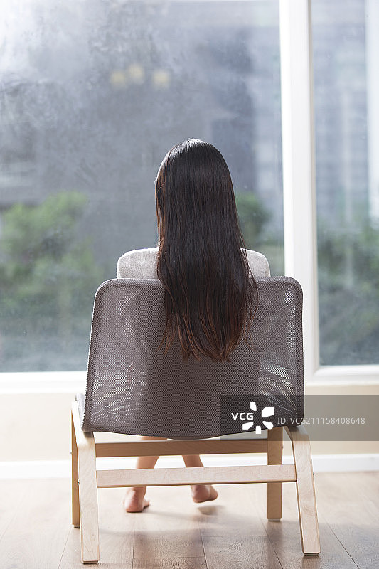 看向窗外的年轻女子图片素材