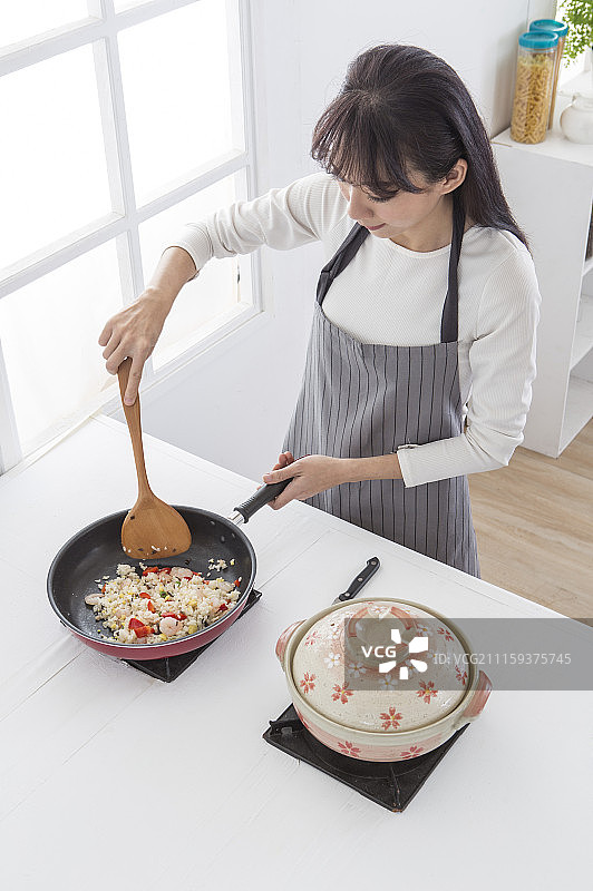 年轻女人在炒饭图片素材